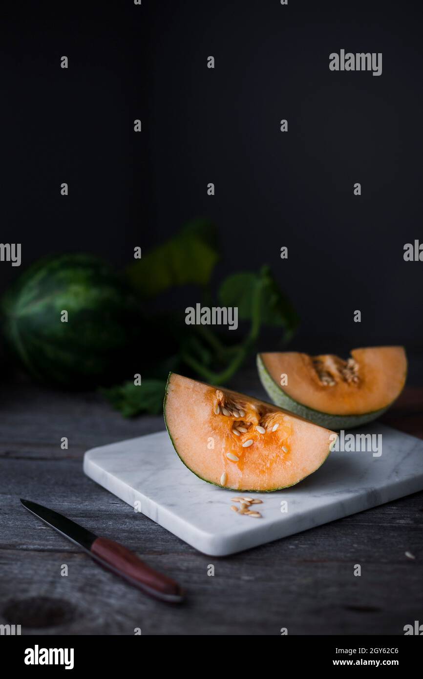 Eine viergeteilte Melone auf einem Marmorbrett Stockfoto