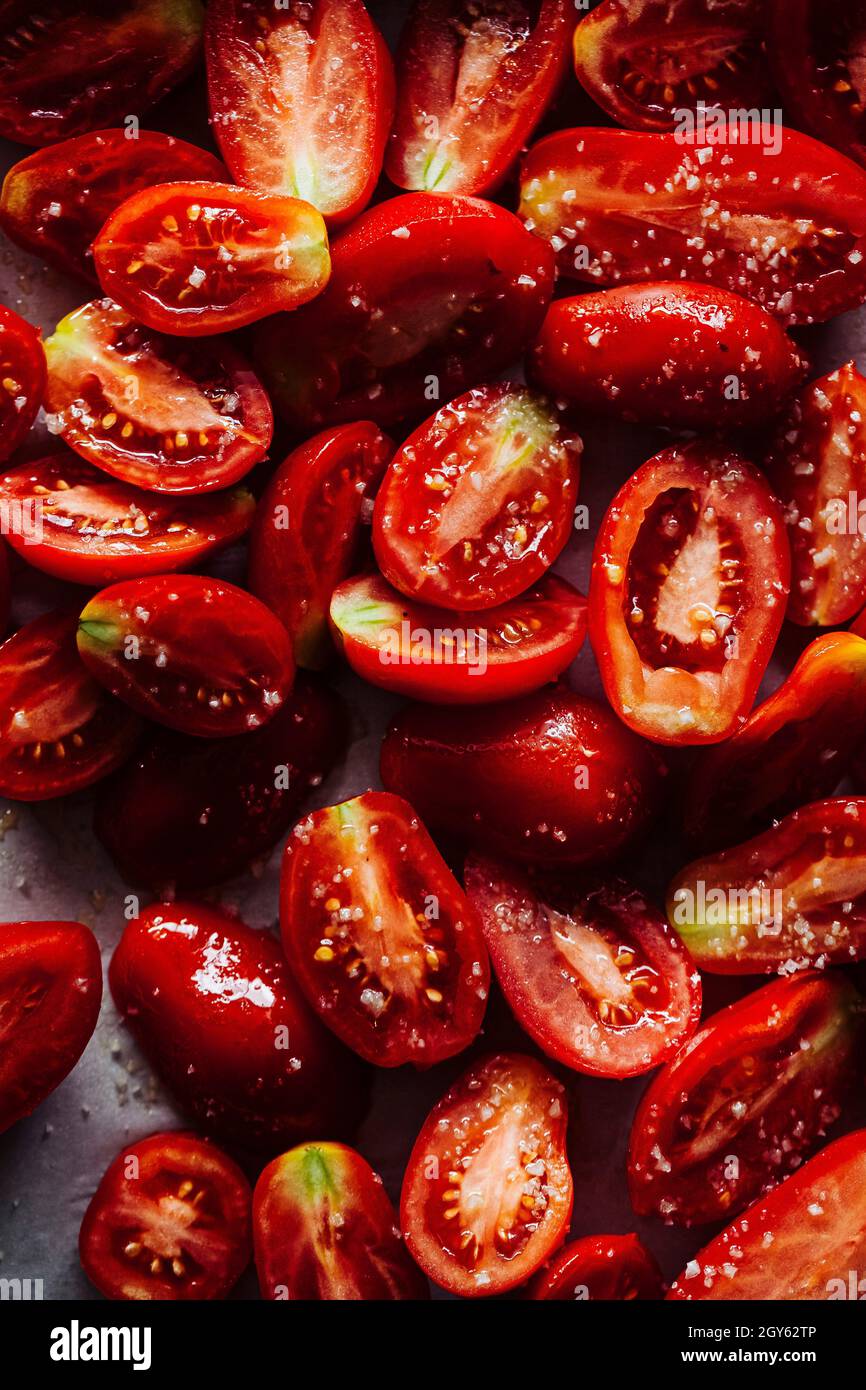 Halbierte Tomaten, gewürzt mit Salz und Olivenöl Stockfoto