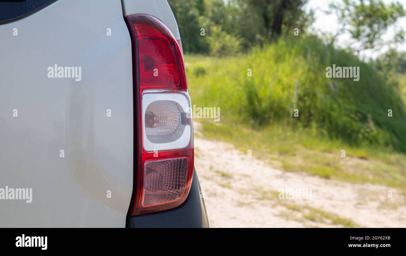 Rechter Heckscheinwerfer. Das Heck eines kleinen Beifahrerhecks oder SUV eines weißen Autos mit einer Gruppe von Schlussleuchten und einem Teil des Kofferraumdeckels auf der Rückseite Stockfoto