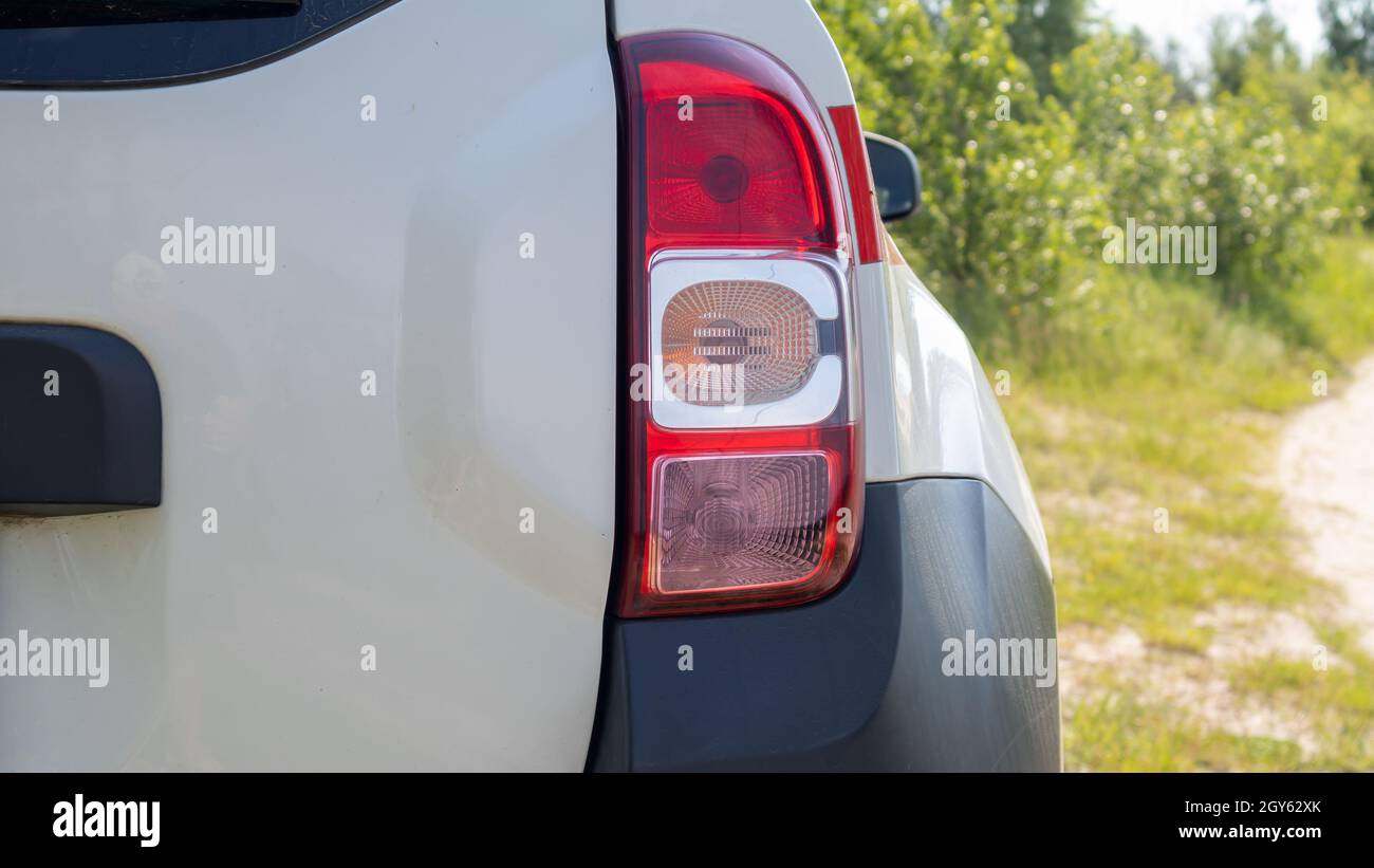 Rechter Heckscheinwerfer. Das Heck eines kleinen Beifahrerhecks oder SUV eines weißen Autos mit einer Gruppe von Schlussleuchten und einem Teil des Kofferraumdeckels auf der Rückseite Stockfoto
