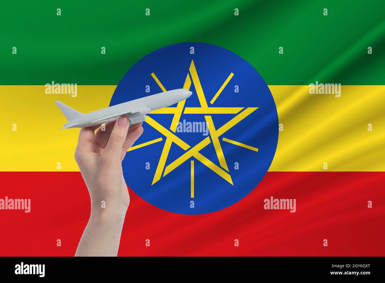Flugzeug in der Hand mit der Nationalflagge Äthiopiens Reise nach Äthiopien. Stockfoto