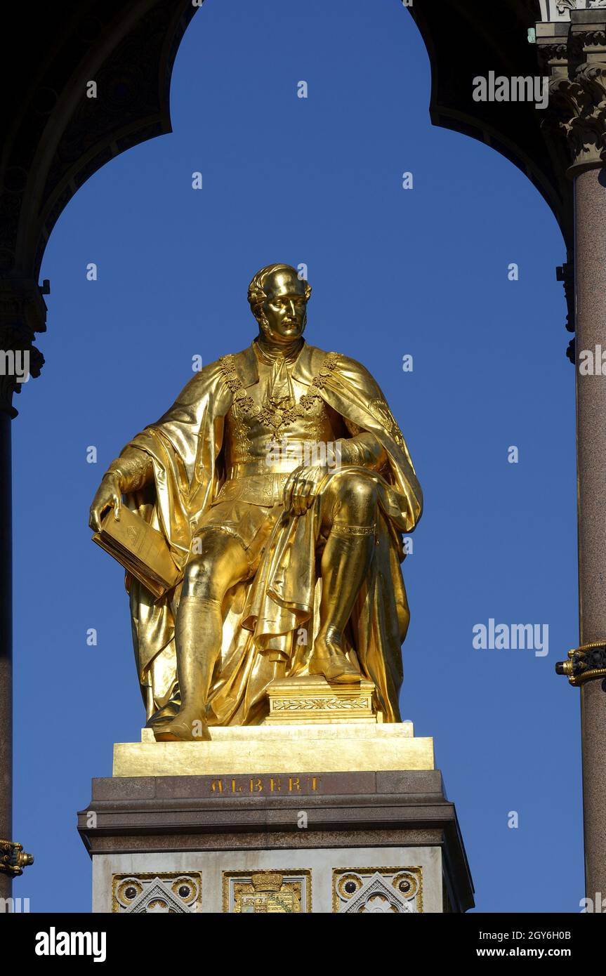 London, England, Großbritannien. Albert Memorial (1872: George Gilbert Scott) in Kensington Gardens. Vergoldete Statue von Prinz Albert mit dem Katalog des G Stockfoto