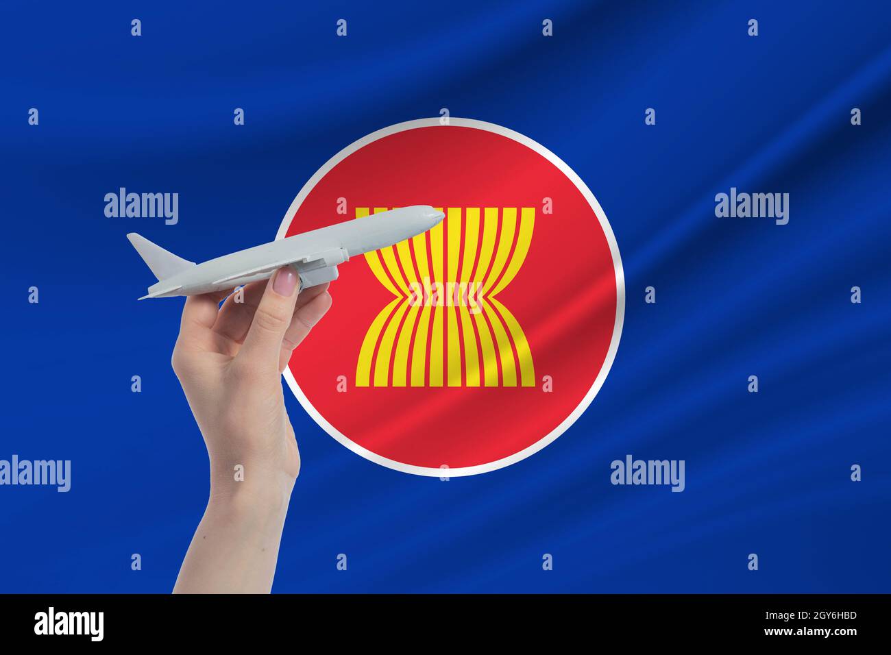 Flugzeug in der Hand mit der Nationalflagge der Vereinigung südostasiatischer Nationen. Reisen Sie zur Vereinigung südostasiatischer Nationen. Stockfoto