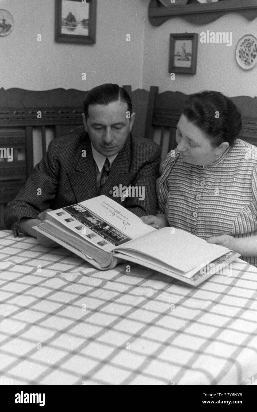 Die Inhaber des Musterbetriebs Wilhelm Pflaume mit einem Fotoalbum, Deutsches Reich 1941. Eigentümer der Modellpflanze Wilhelm Pflaume mit einem Fotoalbum, Deutschland 1941. Stockfoto