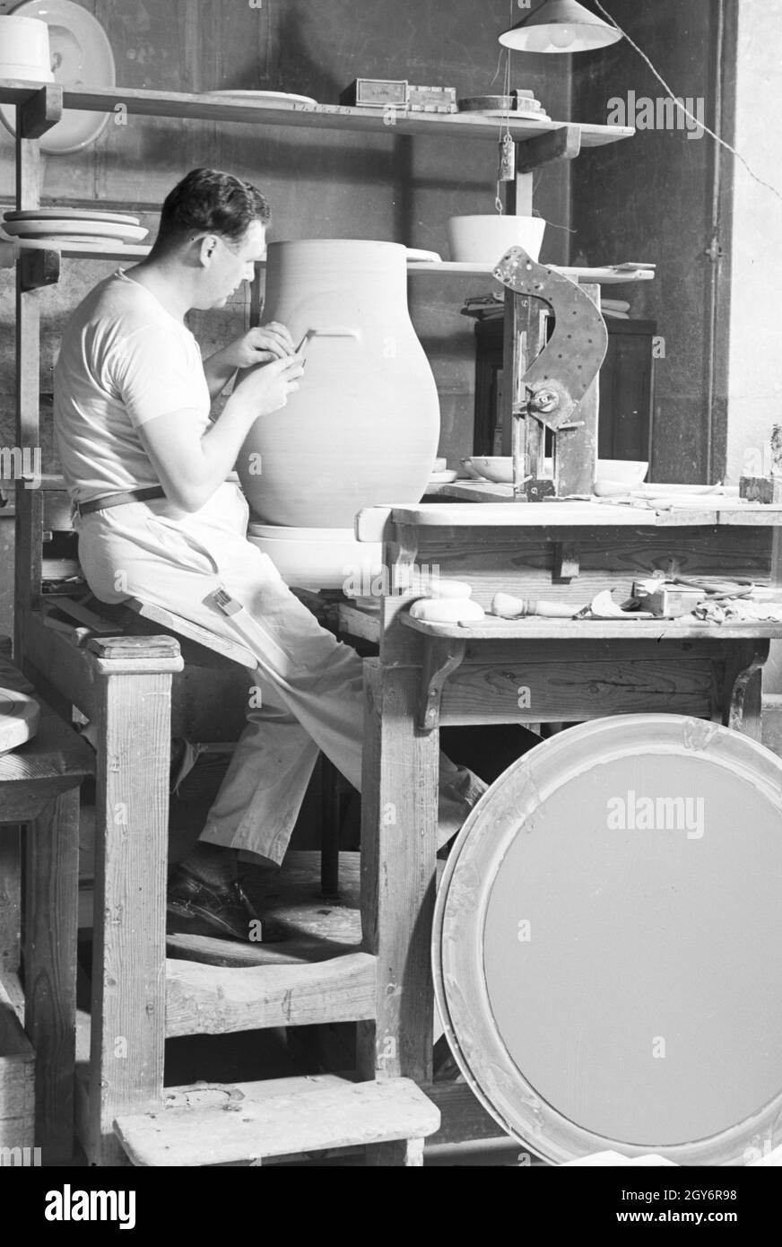 Ein Keramiker der Staatlichen Porzellanmanufaktur Berlin bei der Arbeit ein einer großen Vase, Deutschland 1930er Jahre. Keramikerin der Staatlichen Porzellanmanufaktur Berlin arbeiten auf einer großen Vase, Deutschland 1930. Stockfoto