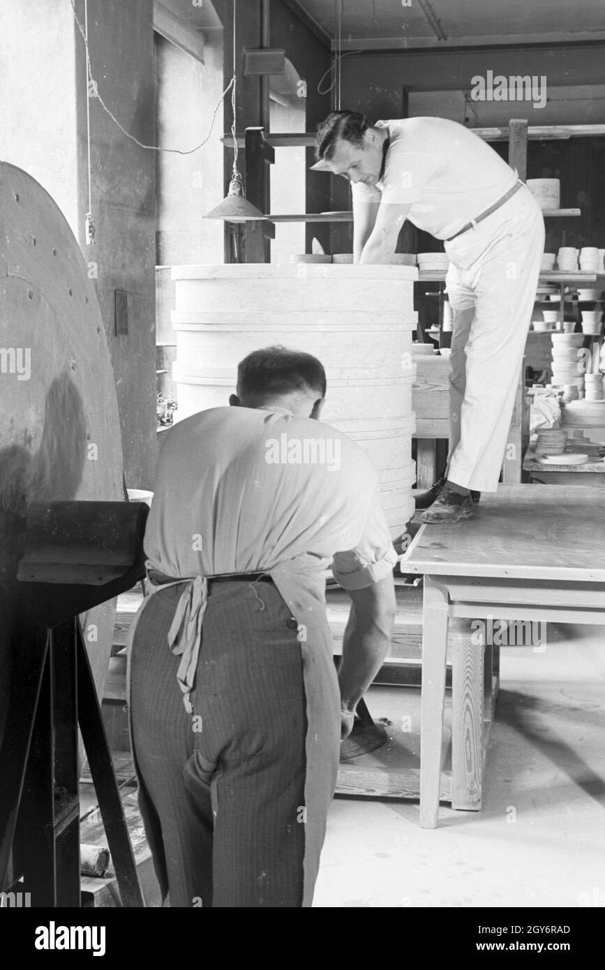 Keramiker der Staatlichen Porzellanmanufaktur Berlin sortieren Porzellanware für den Schrühbrand, Deutschland 1930er Jahre. Keramiker der Staatlichen Porzellanmanufaktur Berlin sammeln Porzellan für die glost Feuern, Deutschland 1930. Stockfoto