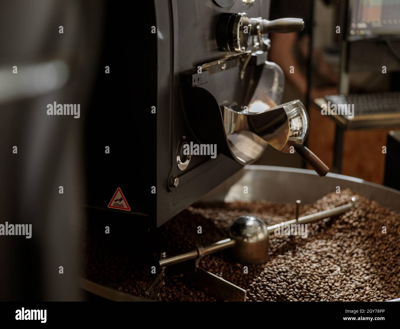 Kaffeeröstermaschine mit Kaffeebohnen in Kühltablett Stockfoto
