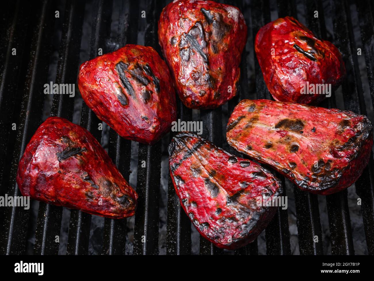 Nahaufnahme Kochen frische neue rote Rüben Wurzeln in Outdoor Holzkohlegrill mit Gusseisen Metallgitter, High-Angle-Ansicht Stockfoto