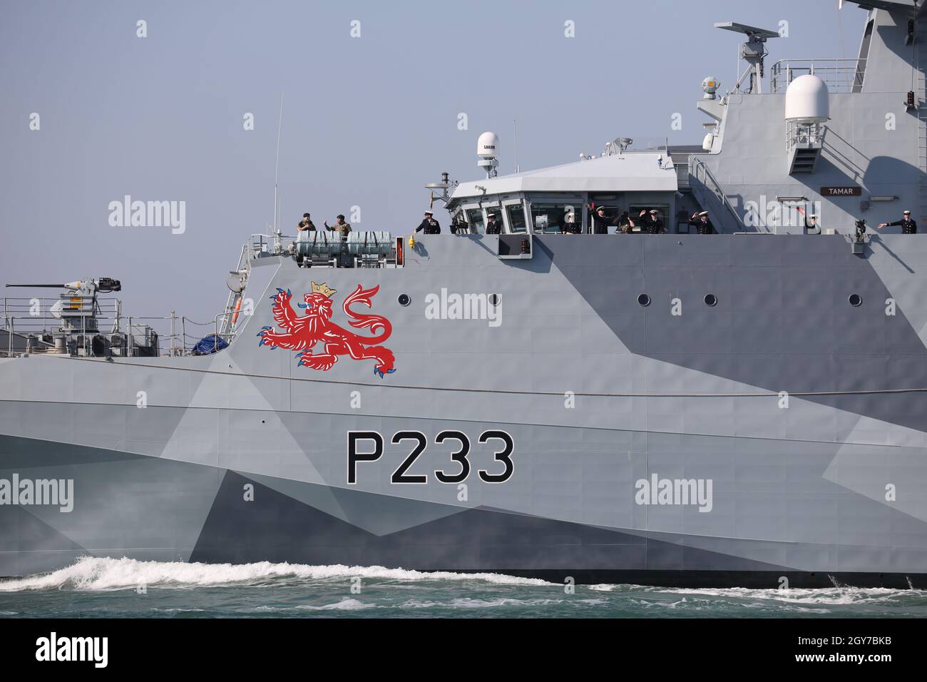 Die Besatzung des Royal Navy-Patrouillenschiffs HMS TAMAR winkt in Richtung Ufer, während das Schiff auf einen langfristigen Einsatz in der Indo-Pazifik-Region abfährt Stockfoto