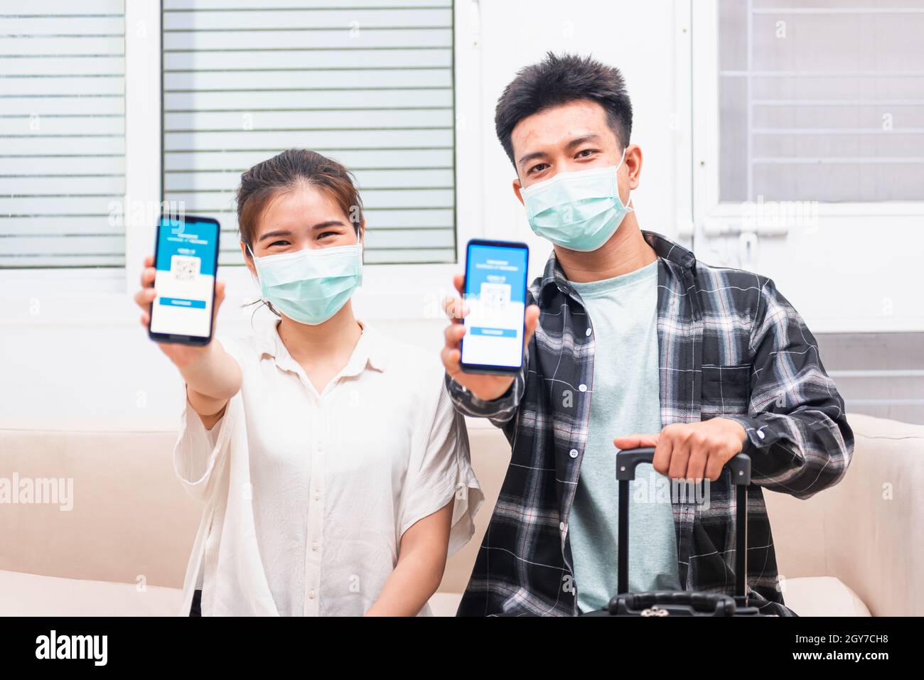 Asiatische junge Paar Frau und Mann bereit zu reisen zeigen digitale Impfstoff Gesundheit Pass Zertifikat App auf dem Smartphone-Bildschirm während Coronavirus pande Stockfoto
