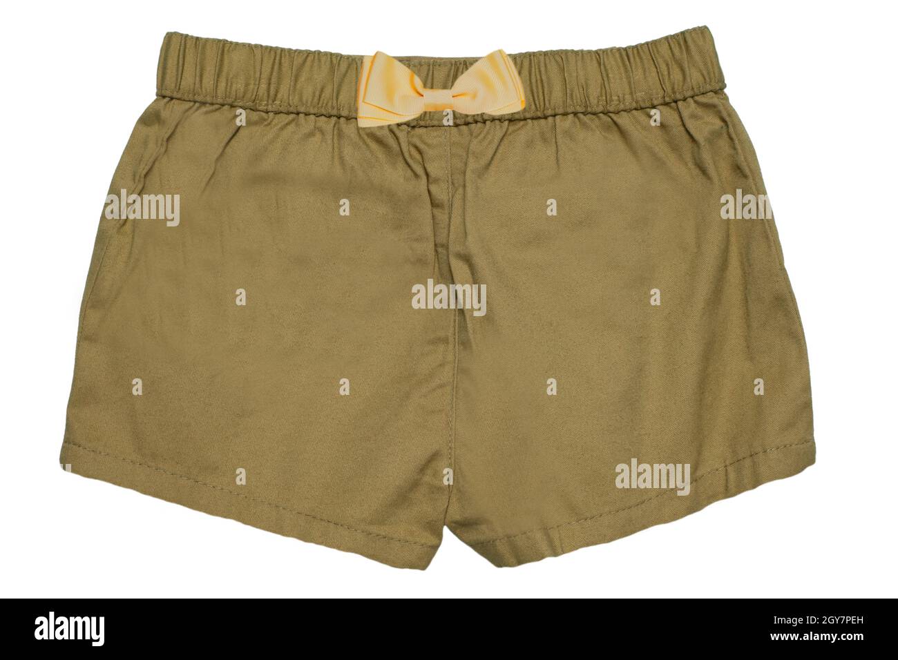 Sommershorts isoliert. Nahaufnahme einer stylischen, modischen senffarbenen kurzen Hose mit gelber Schleife für das kleine Mädchen, isoliert auf einem weißen Stockfoto