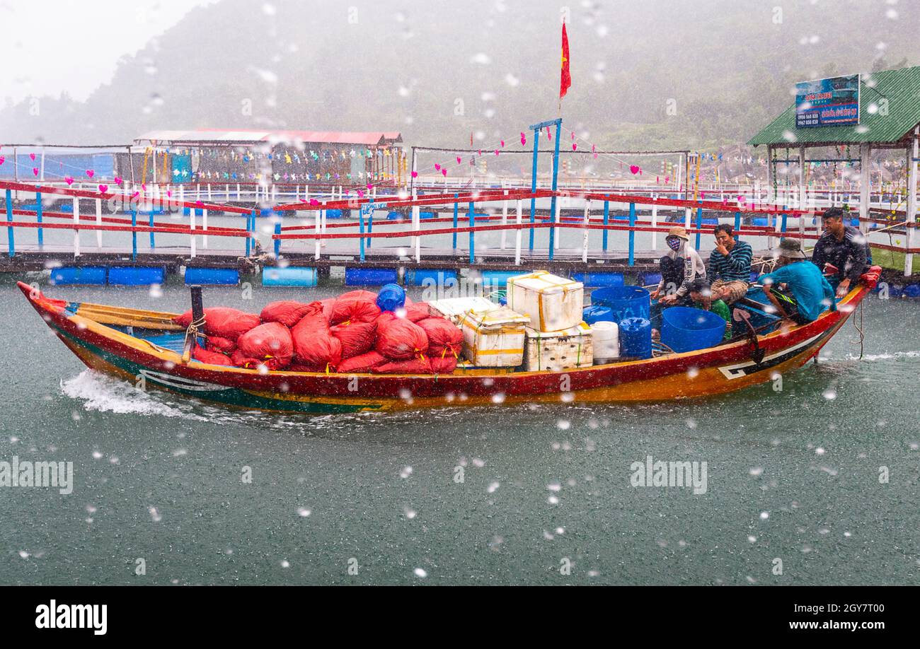 Ein Boot geht während eines Regenguß und rauer See hinaus, um Produkt zu liefern. Stockfoto