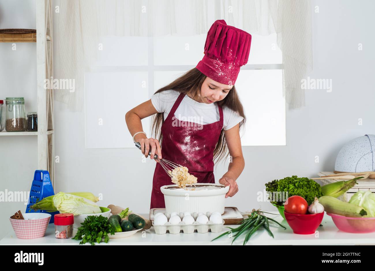 Mädchen Kind in Koch Schürze und Hut Kochen, ökologisch Stockfotografie -  Alamy
