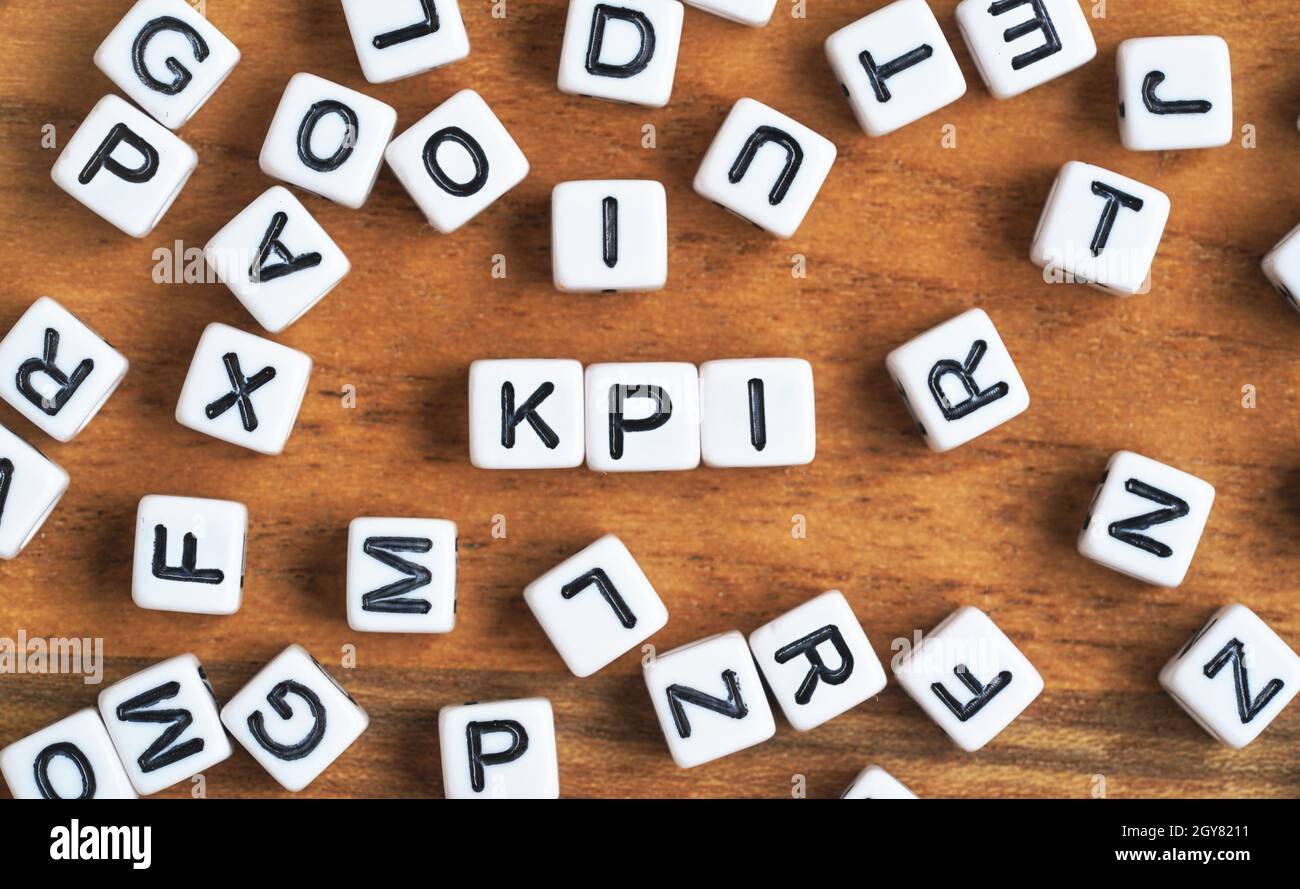 Kleine weiße und schwarze Perlenwürfel auf Holzbrett, Buchstaben in der Mitte buchstabieren KPI - Key Performance Indicators Concept. Stockfoto