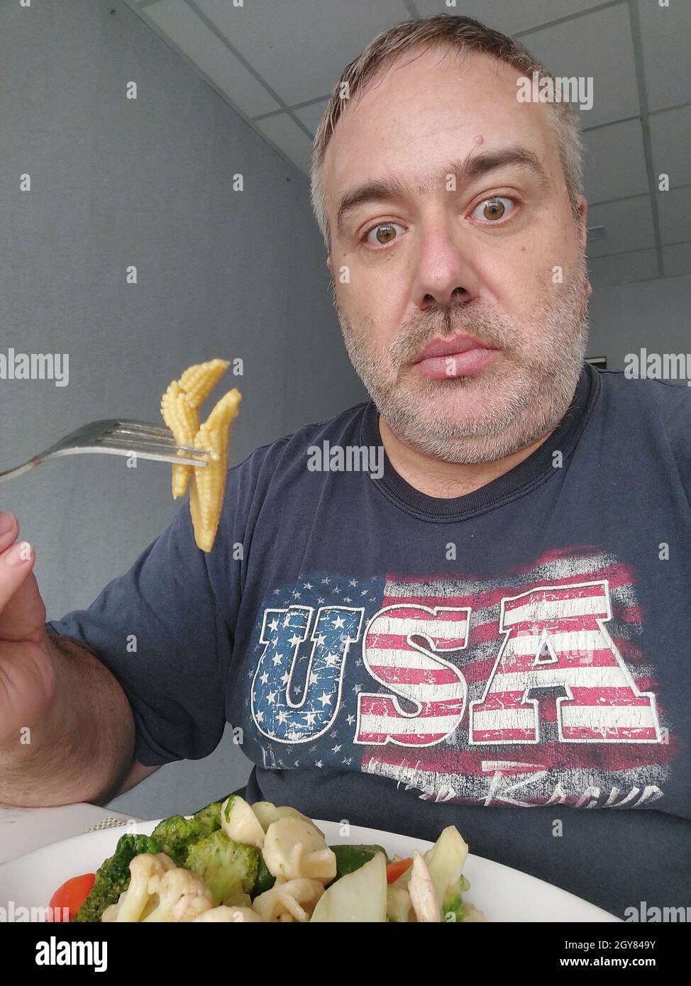 Fat American Man Essen Baby Mais Stockfoto