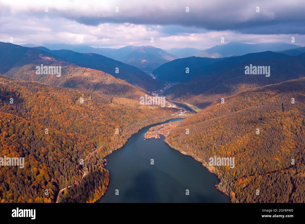 Luftaufnahme auf See mit türkisfarbenem Wasser in den Karpaten. Herbstwald mit Orangenbäumen an der Küste. Terebland-Ritske Stausee (Vilshanske) am Terebland-Fluss, Transkarpatien, Ukraine Stockfoto