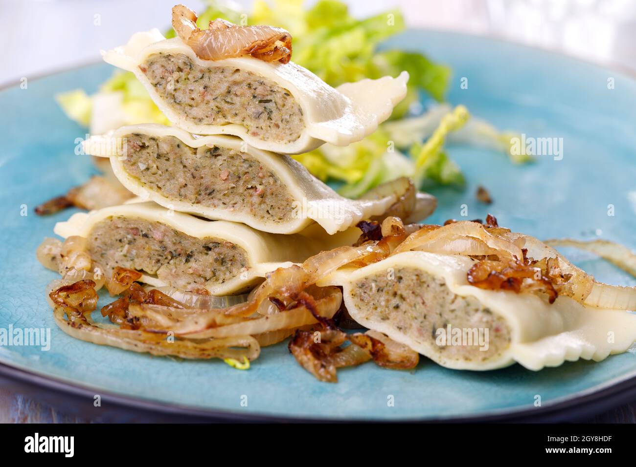 Hälften schwäbische maultaschen Pasta mit Salat Stockfoto
