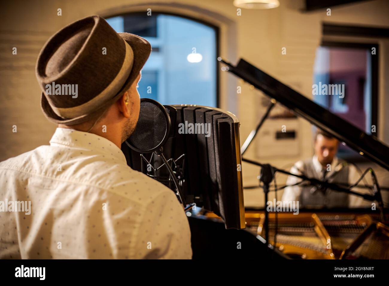 Sänger aus der Nähe von hinten. Pianist im Hintergrund. Stockfoto