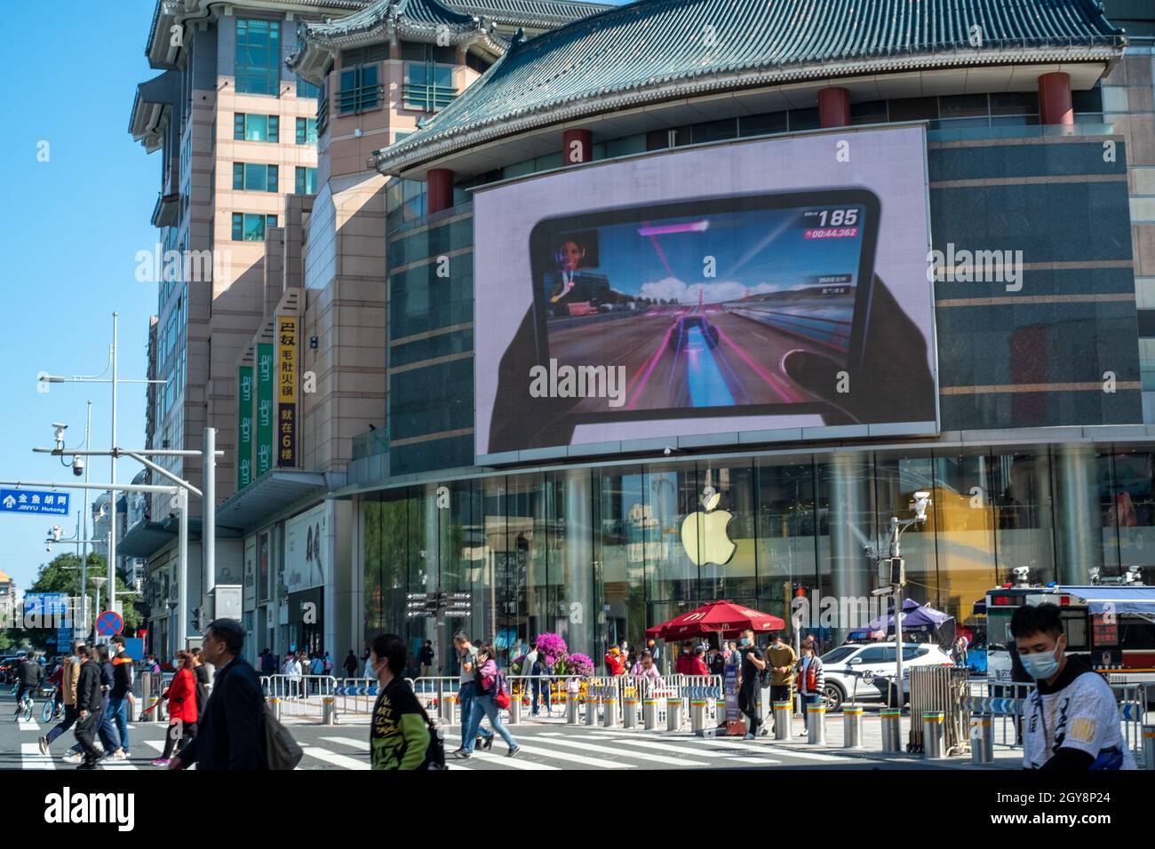 In Peking, China, laufen die Menschen an einem Apfelladen in Wangfujing vorbei, in dem iPad-Mini-Werbung auf einem großen Bildschirm angezeigt wird. 07-Okt-2021 Stockfoto