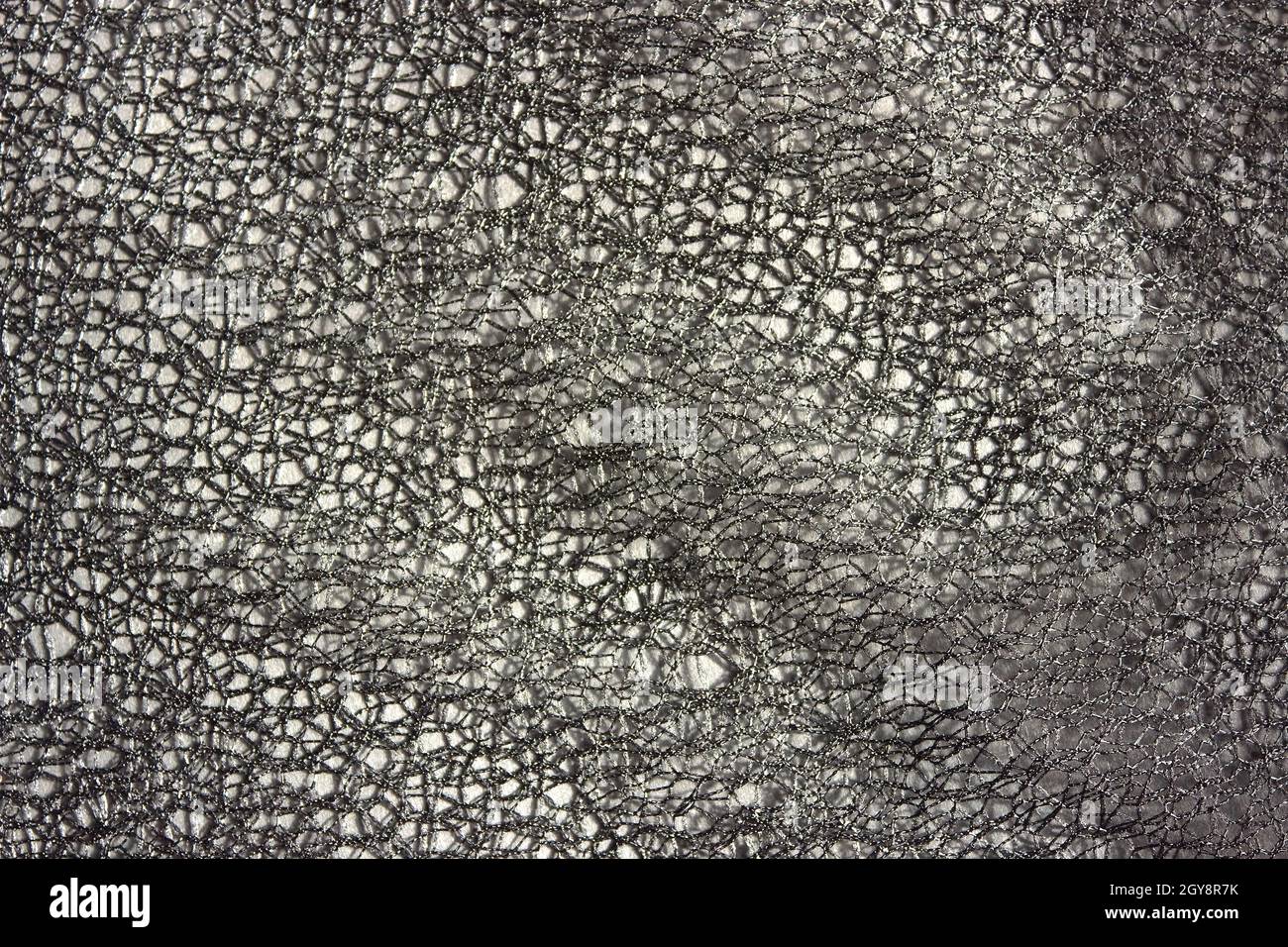 Graue Spitze abstrakter Hintergrund. Dunkler Hintergrund für Design, soziale Netzwerke, Text. Durchbrochen, Mesh, Fabric-Hintergrund. Stockfoto