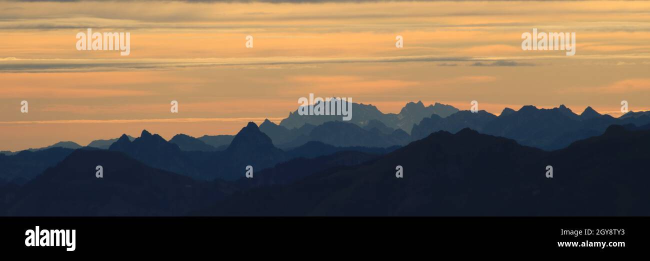 Leuchtend gelber Morgenhimmel über dem Großen Mythos, Saentis und anderen Bergen in den Schweizer Alpen. Stockfoto