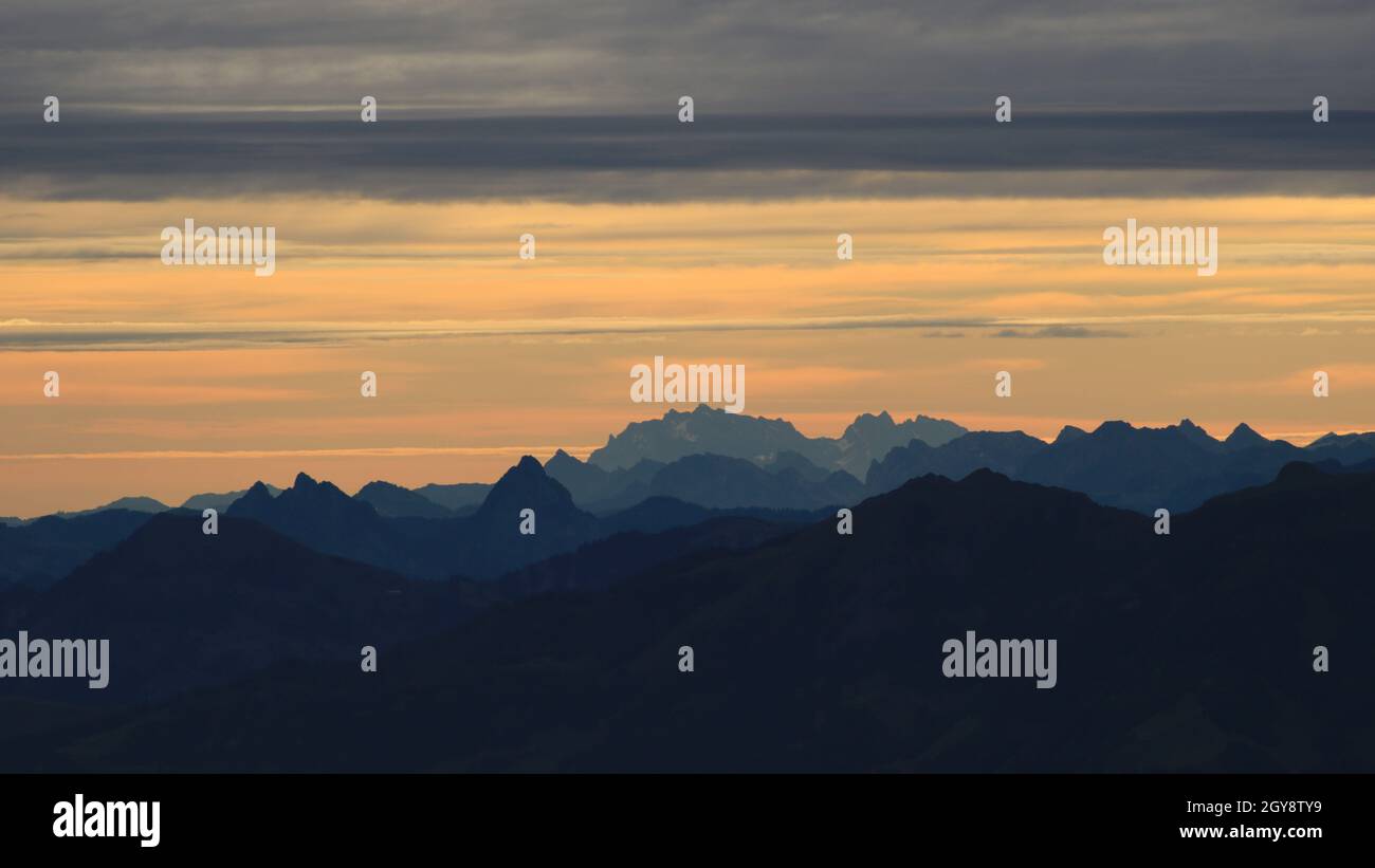 Leuchtend gelber Morgenhimmel über dem Großen Mythos, Saentis und anderen Bergen in den Schweizer Alpen. Stockfoto