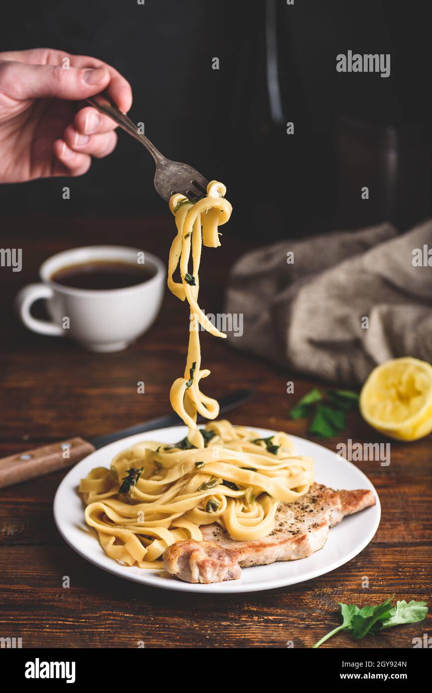 Schweinekotelett und Tagliatelle mit Kapern und Zitronenschale Stockfoto