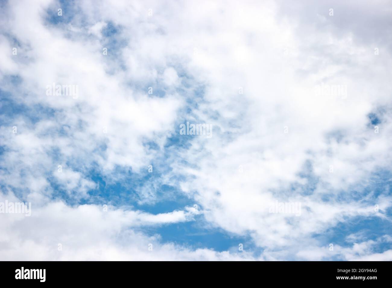 Strahlend blauer Himmel mit kommenden Wolken. Wolkiges Wetter. Das Wetter ändert sich zu schlecht. Horizontales Foto. Abstrakter natürlicher Hintergrund. Stockfoto