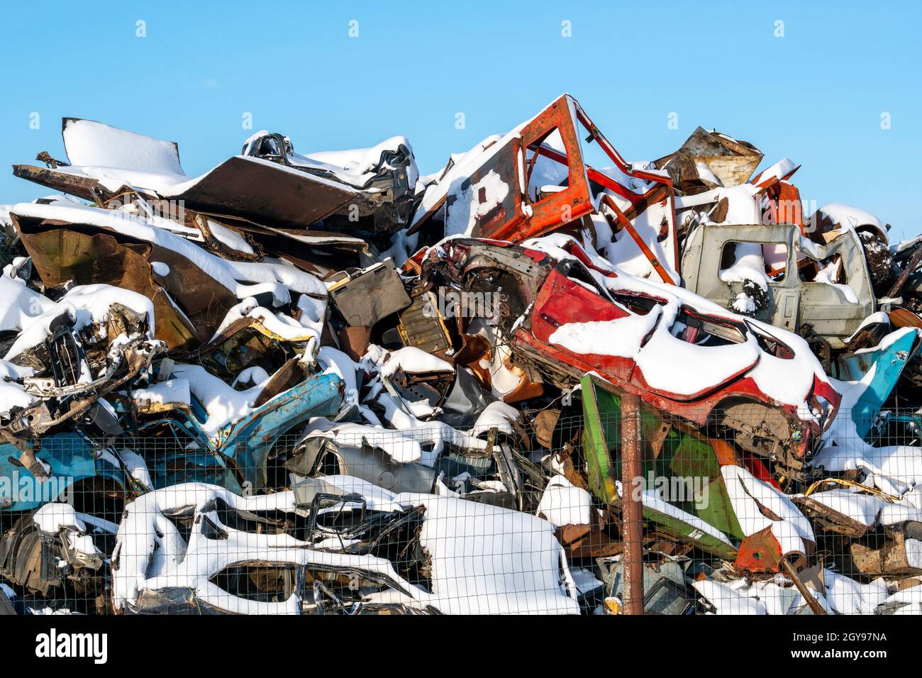 Schrottplatz mit vielen Autos im Schnee. Recycling von Fahrzeugen. Stockfoto