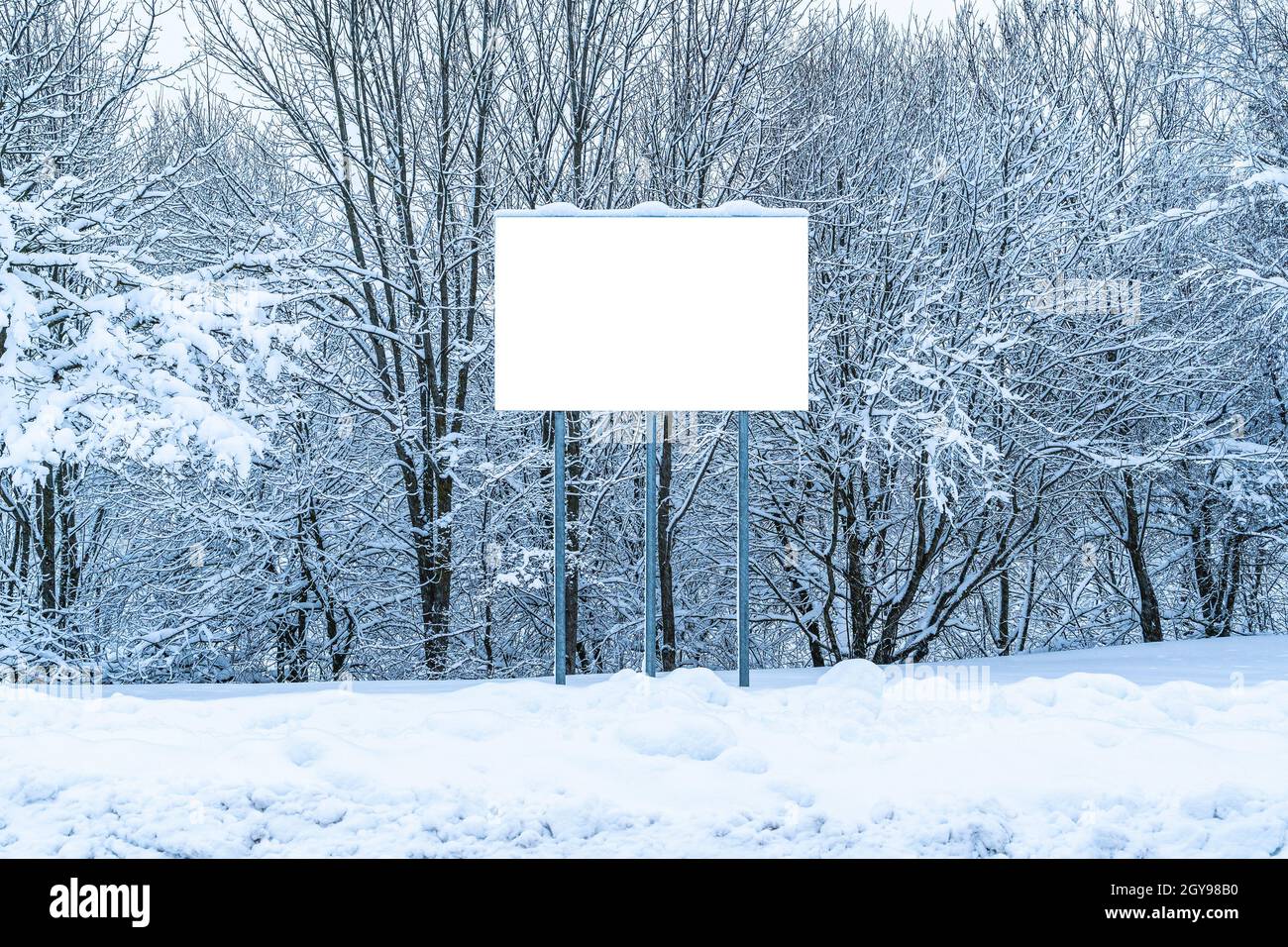Leere Plakatwand, die in einer Schneewehe steht. Mock-up für Werbeplakat. Stockfoto
