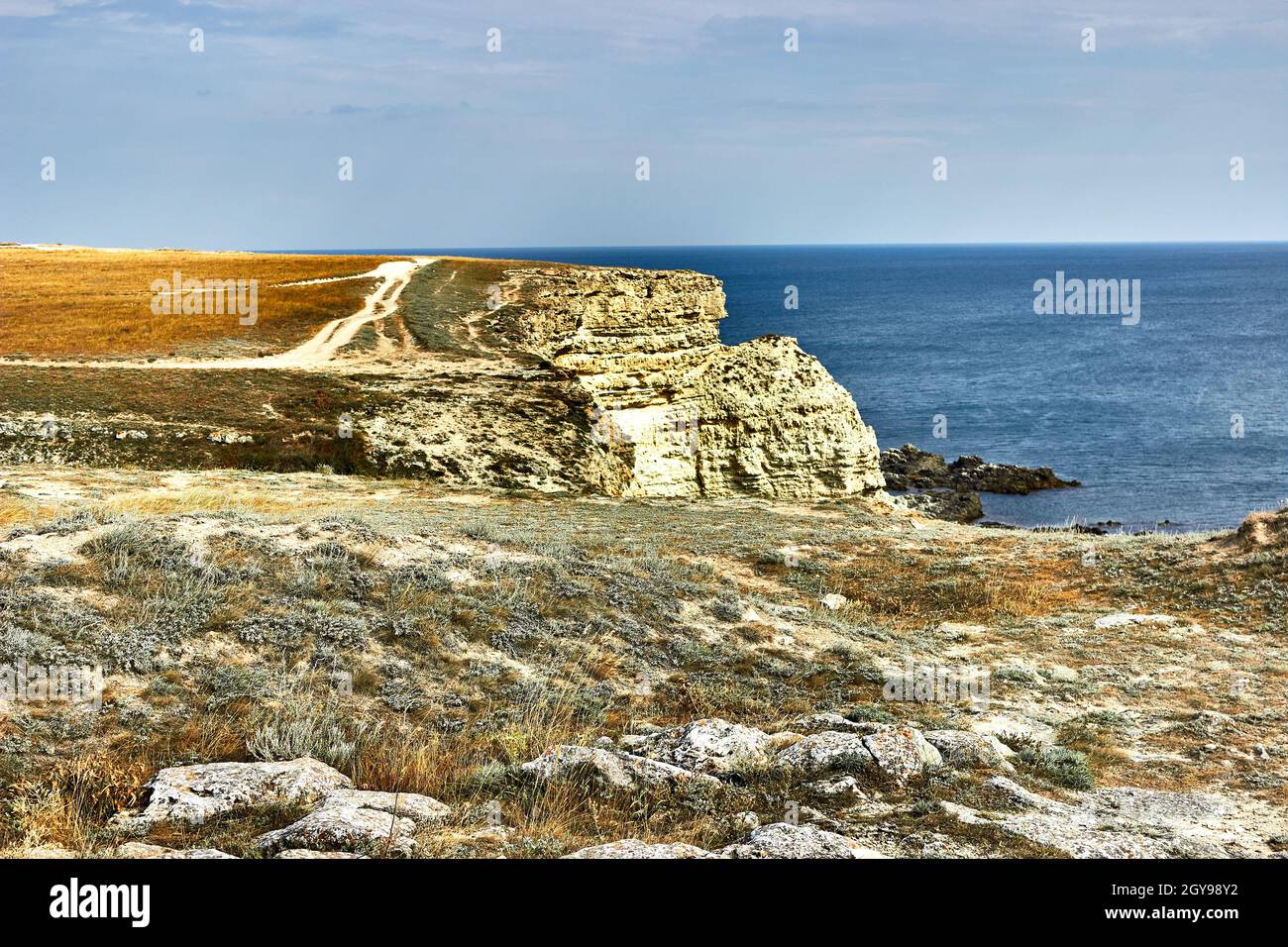 Kreidefelsen, Kap Tarkhankut, Krim. Eine Landstraße am Rande der Klippe. Orange Land, ein Kap am Meer. Seeseite, Horizont, ruhiges blaues Meer. Stockfoto