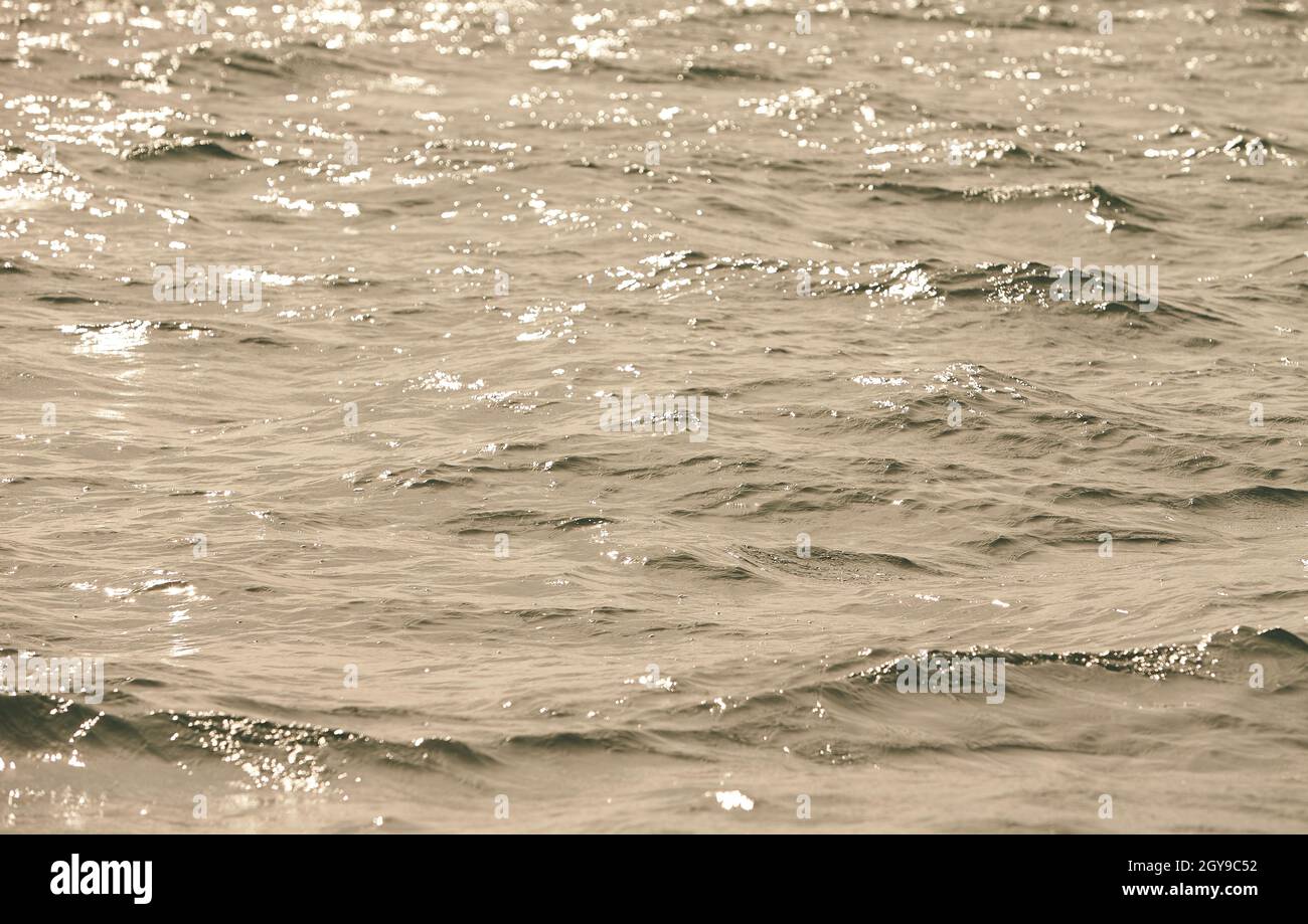 Textur von Glitzerwasser und sanften Wellen. Glitzernd im Wasser - Hintergrund. Meerwasser mit Sonnenblendung und Welligkeit. Kraftvolles und friedliches Naturkonzept. Stockfoto