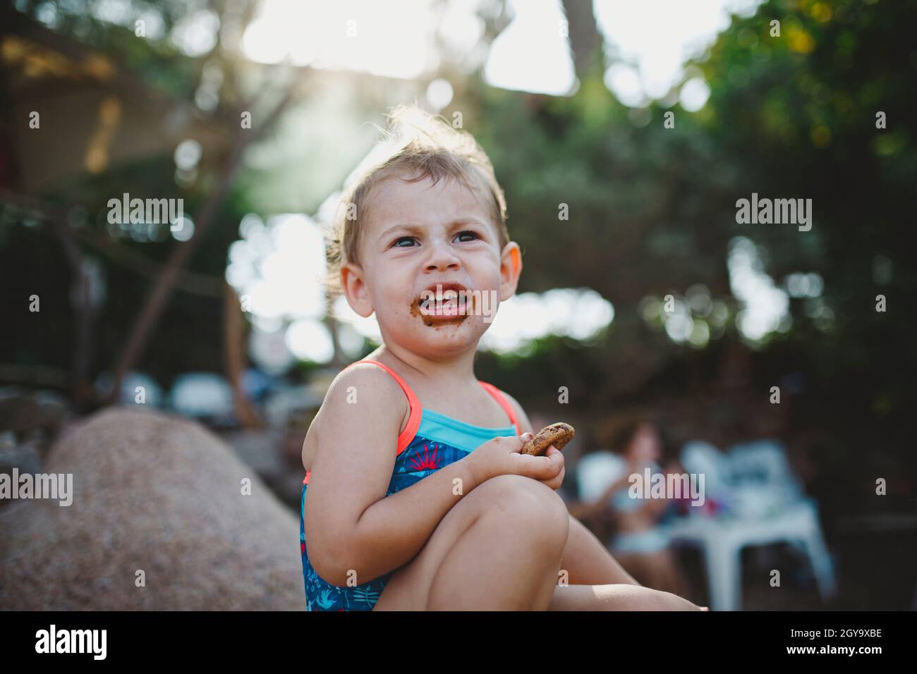 Kleines Mädchen mit einem unordentlichen Gesicht nach dem Essen Cookie Stockfoto
