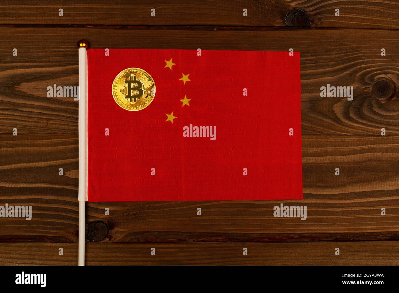Goldbitcoin Kryptowährung Münze auf Flagge von China auf hölzernen braunen Hintergrund. Das Konzept des Hauptlandes für legale Kryptowährungs-Bergbaufarmen Stockfoto