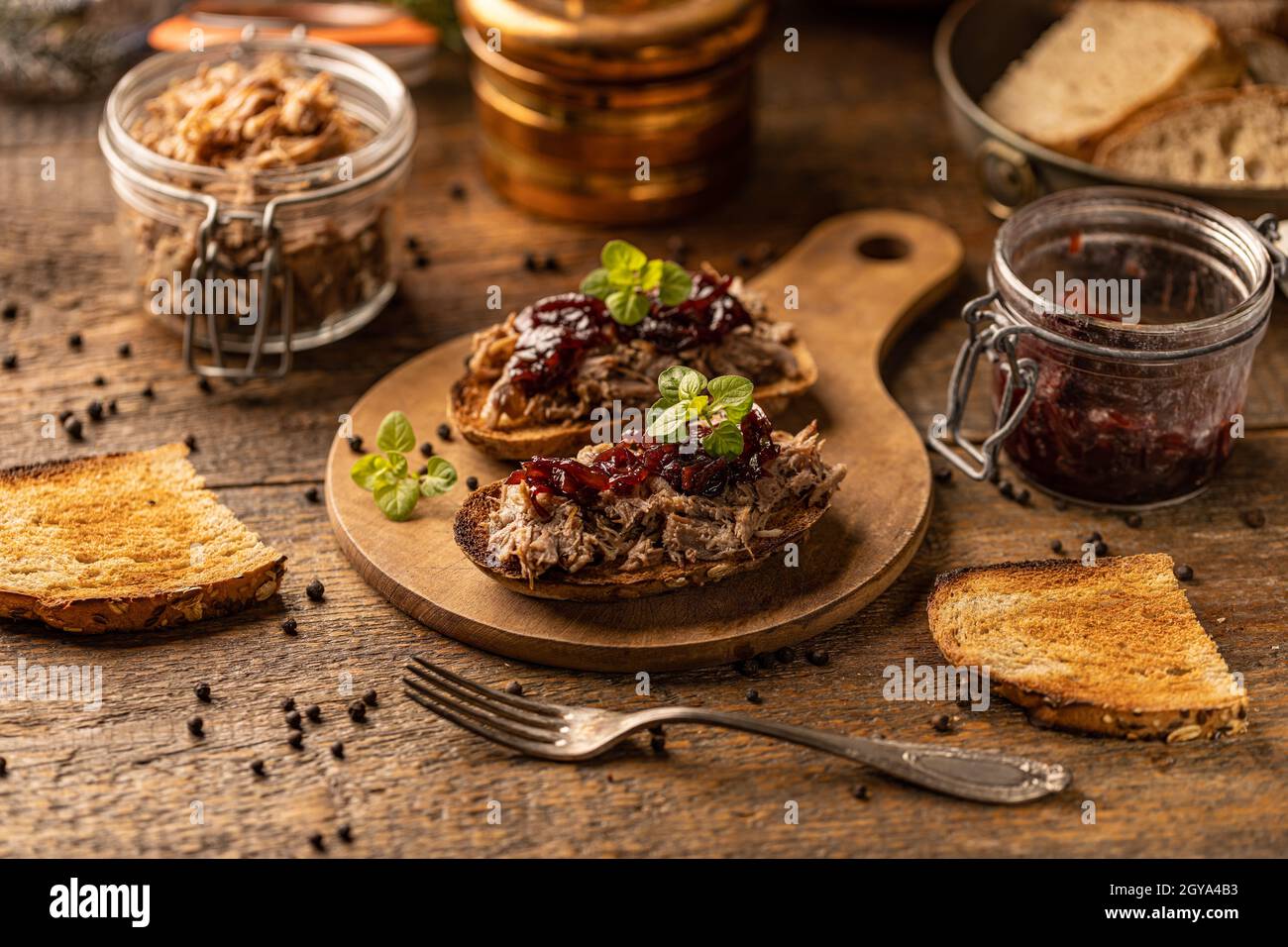 Gezogene Ente mit karamellisierten Zwiebeln auf rustikalem Hintergrund Stockfoto