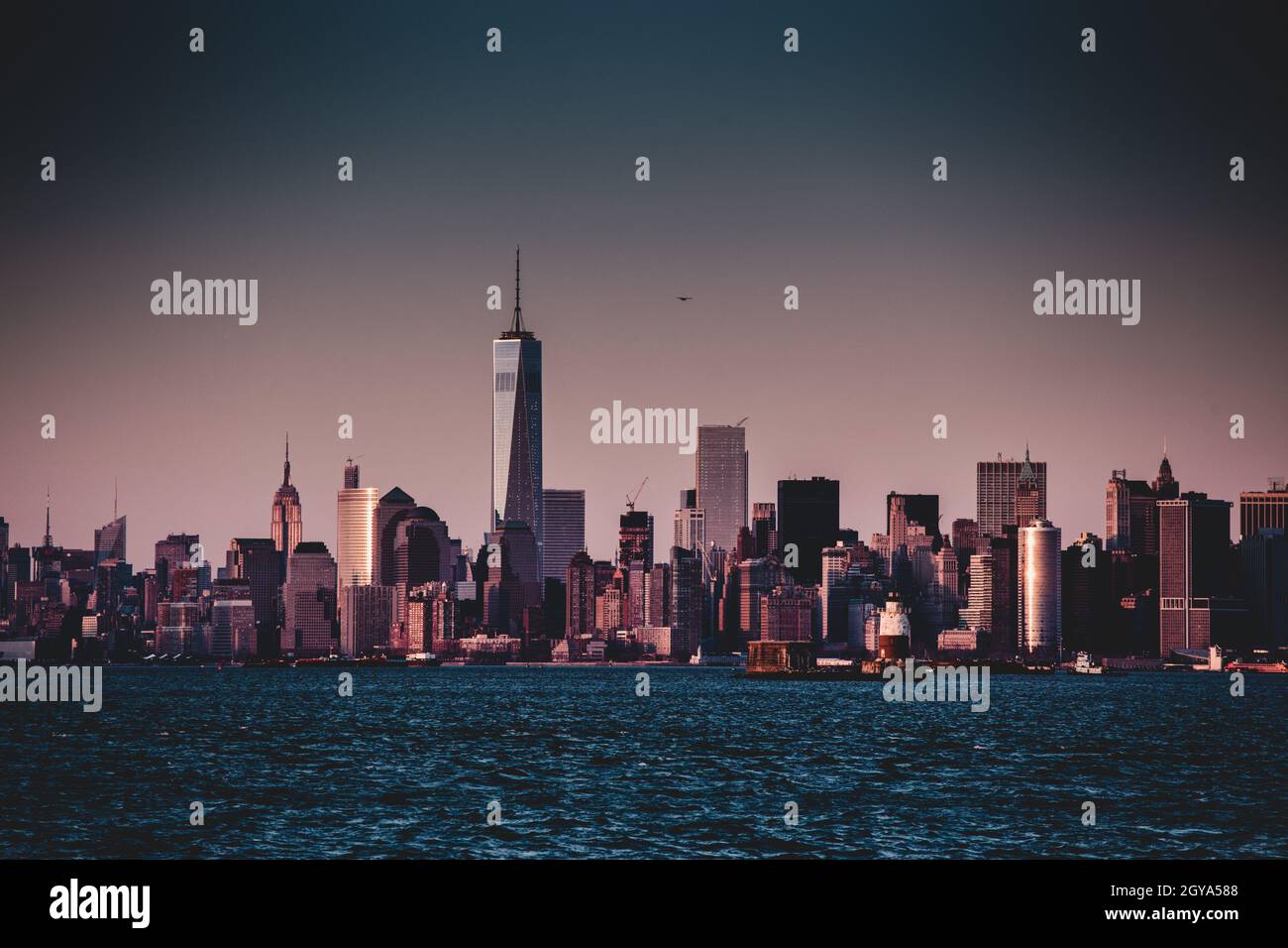 Skyline von New York City Manhattan in der Abenddämmerung mit Wolkenkratzern, die über dem Panorama des Hudson River erleuchtet sind. Vertikale Zusammensetzung. Stockfoto