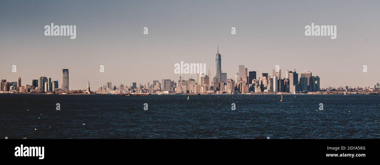 Skyline von New York City Manhattan in der Abenddämmerung mit Wolkenkratzern, die über dem Panorama des Hudson River erleuchtet sind. Vertikale Zusammensetzung. Stockfoto