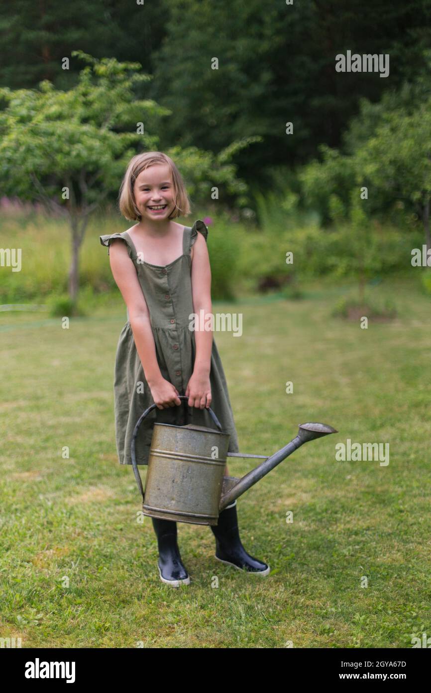 Ein blondes Mädchen hält ein Gartenwerkzeug Stockfoto
