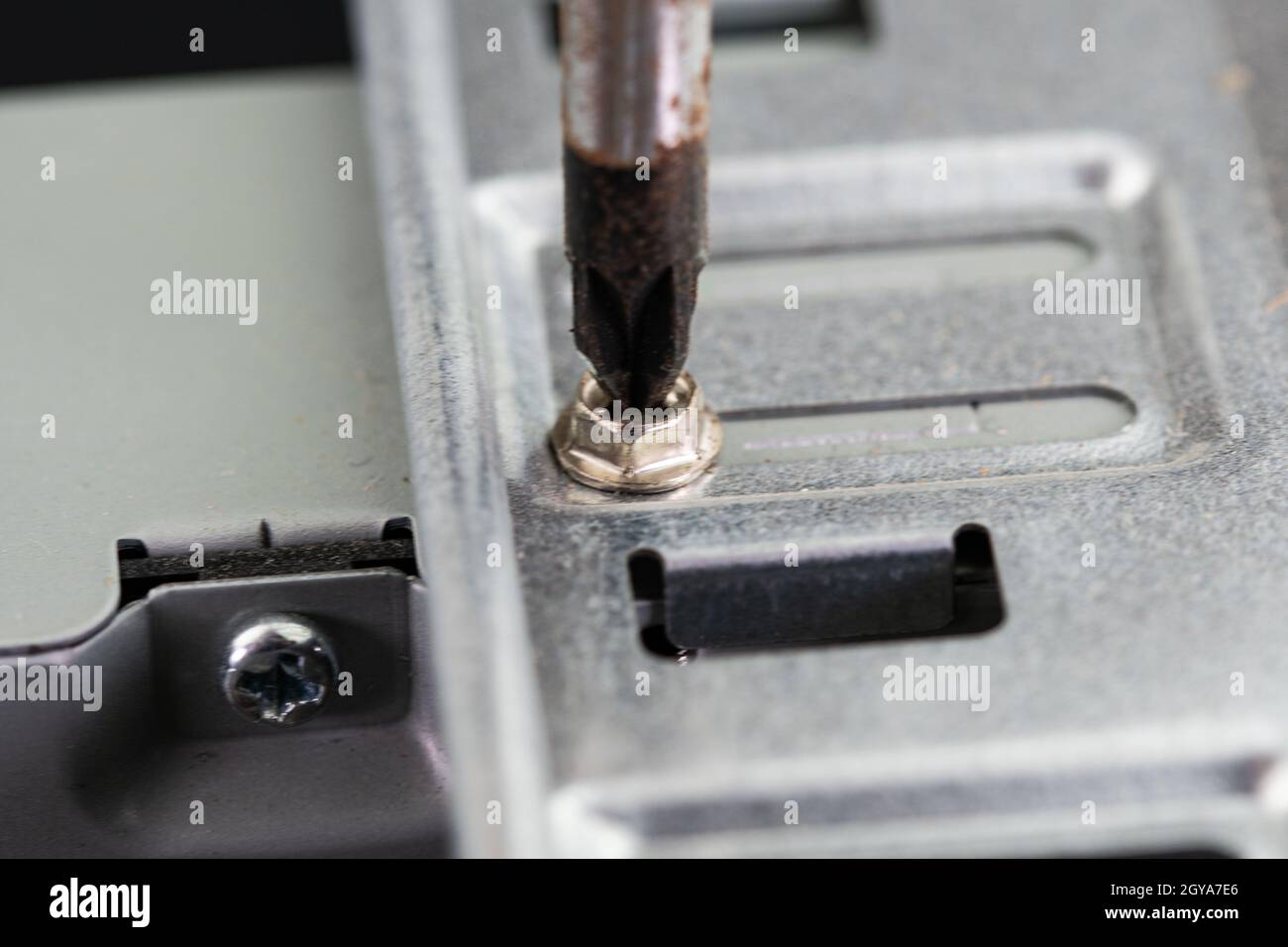 Schraubendreher, mit dem eine Schraube eines pcs auf der Festplattenseite gelöst wird Stockfoto