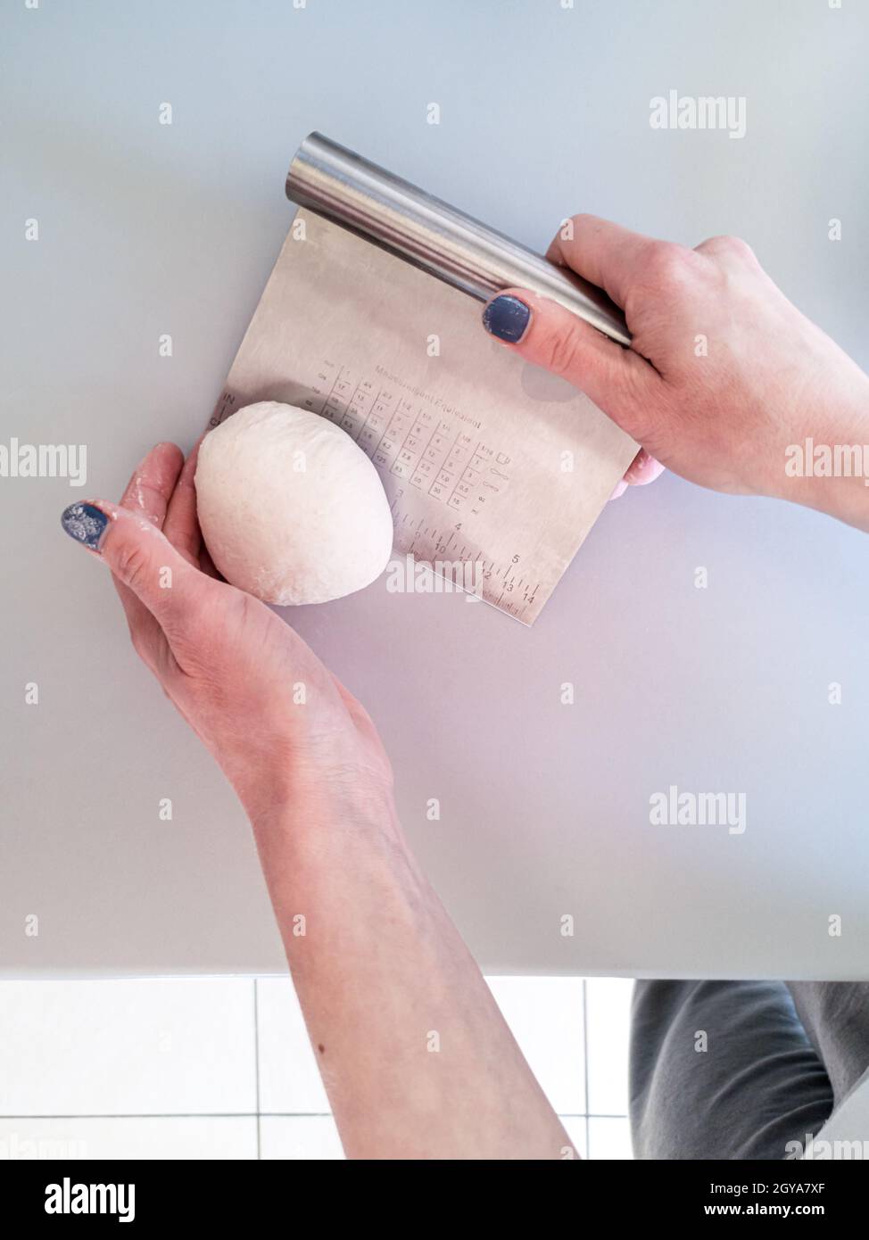 Der Prozess der Zubereitung eines Teiges für Brot mit einem Schaber Stockfoto