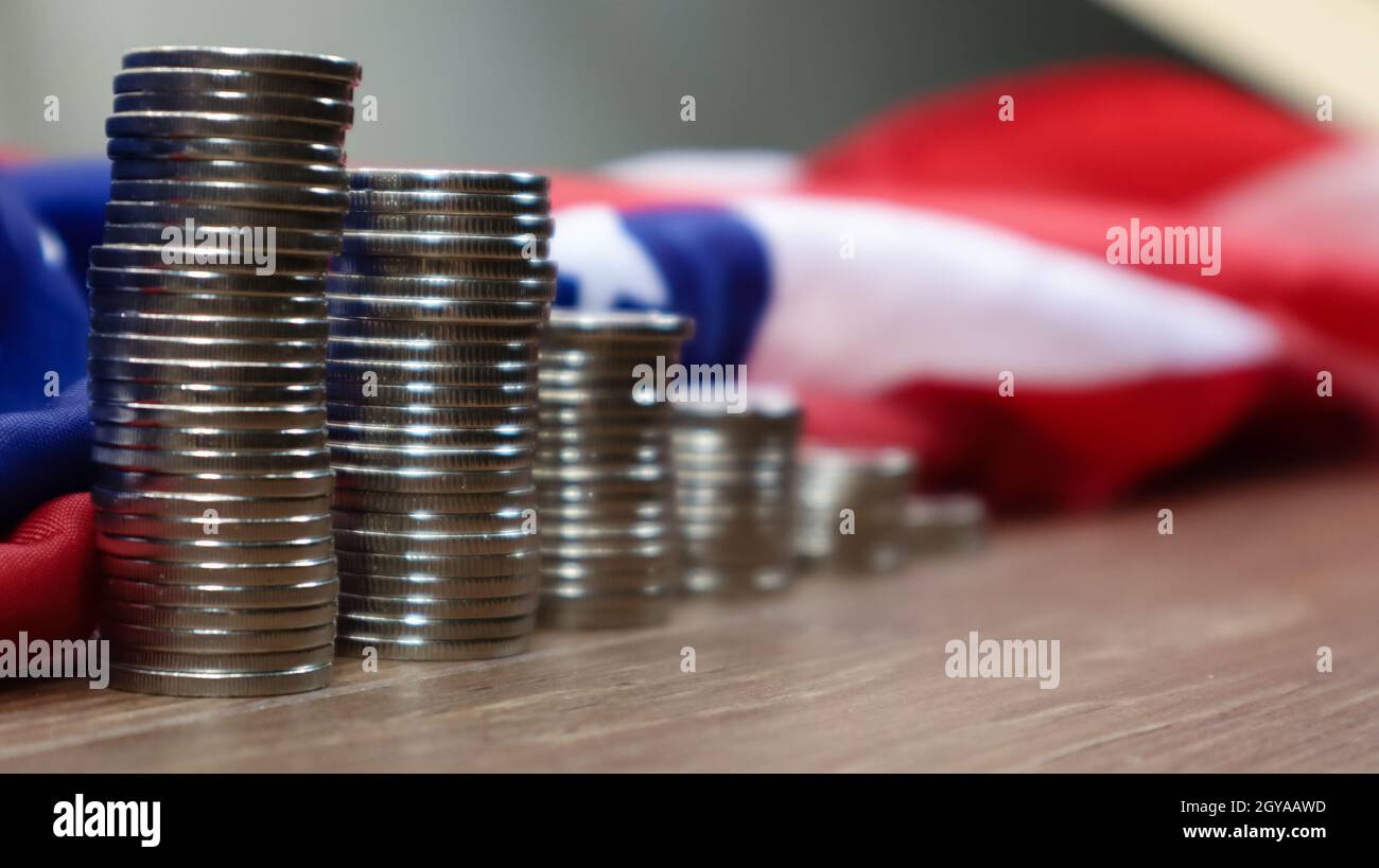 Amerikanische Münzen mit der Flagge der Vereinigten Staaten von Amerika. Investitionskonzept, Unternehmensfinanzierung und Geldeinsparung. US-Münzen gegen den Rücken gestapelt Stockfoto