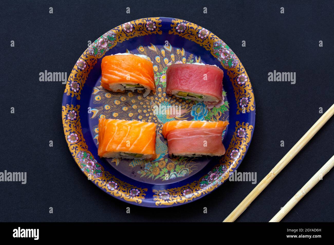 Kalifornische Sushi-Rollen mit Avocado, Gurke und Käse, eingewickelt in Lachs und Thunfisch Stockfoto
