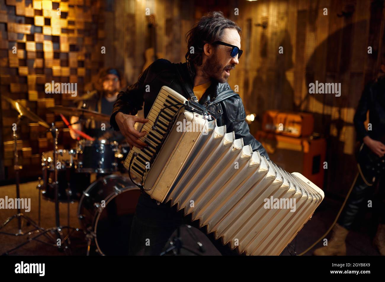 Zwei brutale Musiker mit Akkordeon und E-Gitarre, Musik auf der Bühne. Rockband-Performance, Konzertwiederholung in der Garage, Mann mit Musik Stockfoto