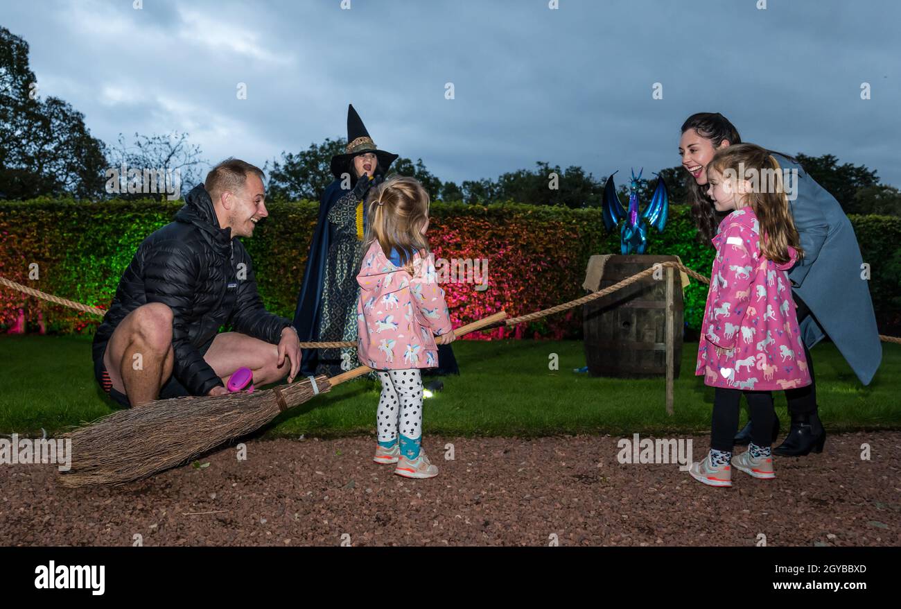 Edinburgh Zoo, Schottland, Großbritannien, 07. Oktober 2021. Halloween Trail im Zoo von Edinburgh: Das erste Halloween-Event des Zoos, ‘Spooktacular’, ist ein beleuchteter Trail, der von NL Productions, dem Team hinter dem Enchanted Forest in Pitlochry, entworfen wurde. Besucher kommen durch den Park und treffen auf gruselige Charaktere, darunter eine Hexe mit einem Besenstiel. Ein junges Mädchen versucht, auf dem Broomstick zu reiten Stockfoto