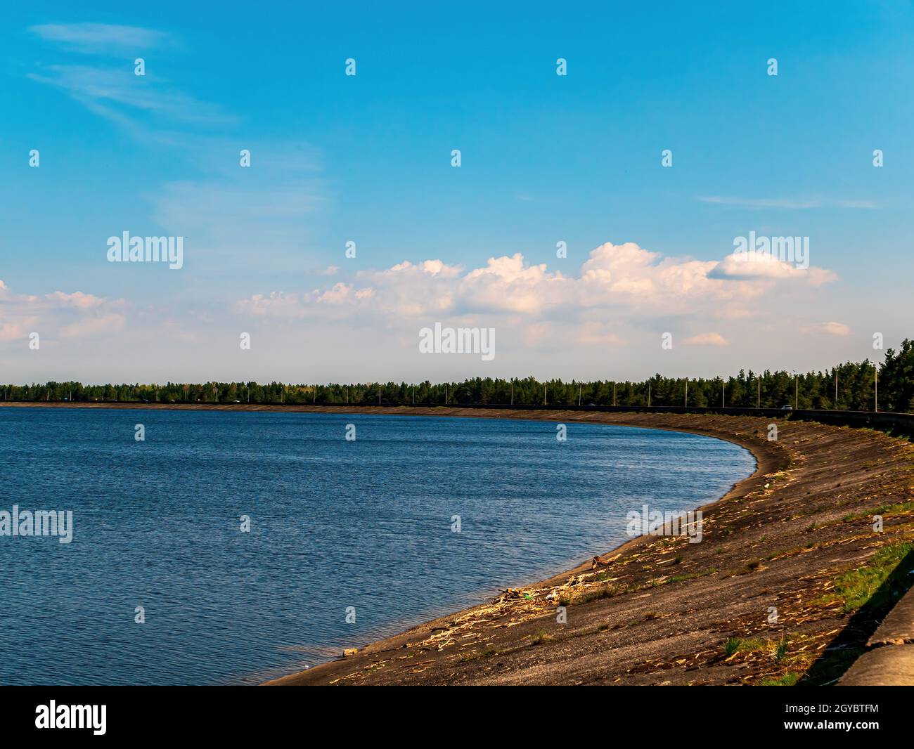 Betondamm eines künstlichen Stausees des flusses dnjepr. Künstliches Meer. Dnepr River. Meereshorizont. Blauer Himmel. Weißer Cumulus oyulaka. Industrielle fa Stockfoto