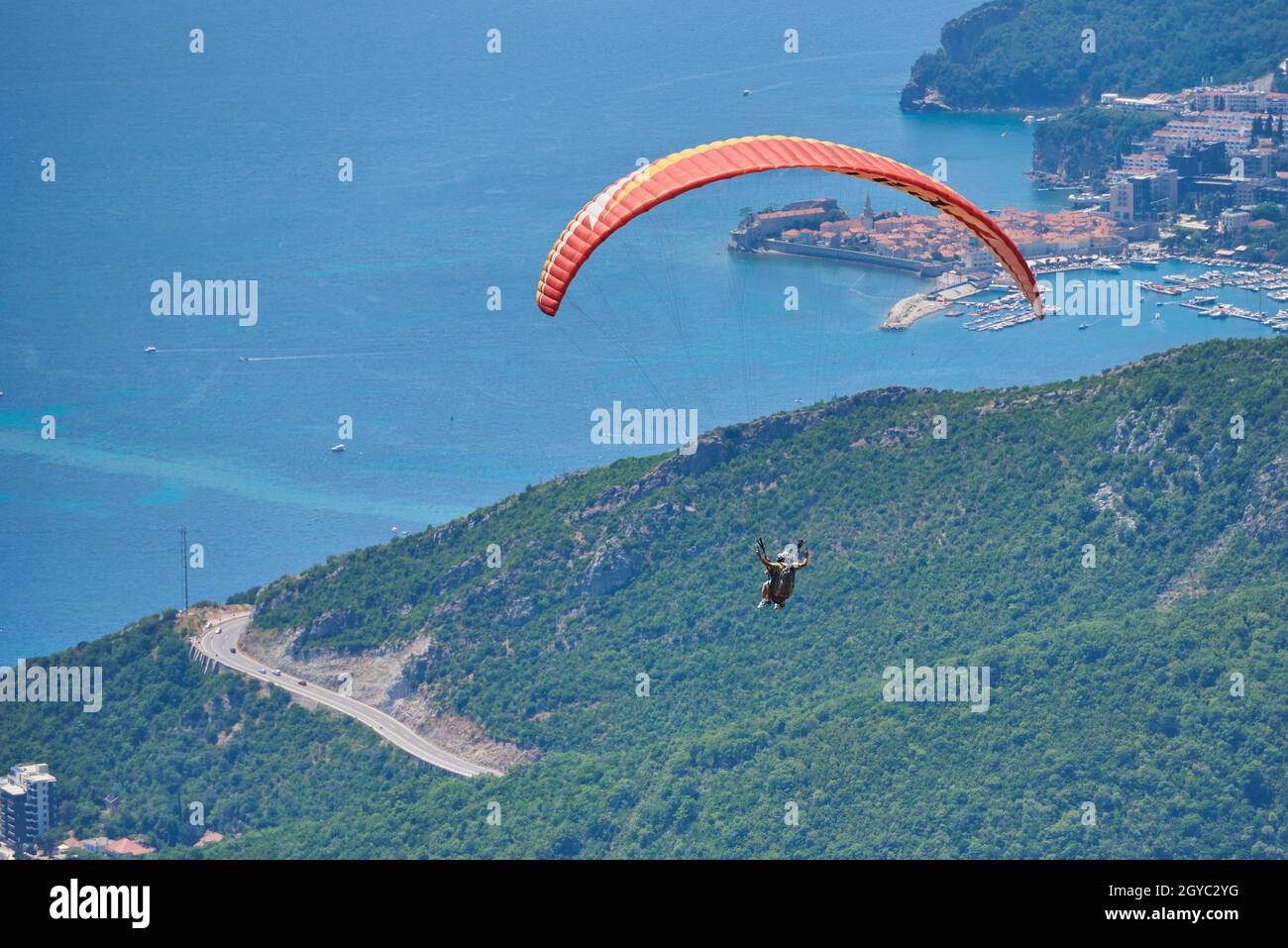 Zwei Personen fliegen mit Paragliding gegen die Stadt Budva Stockfoto