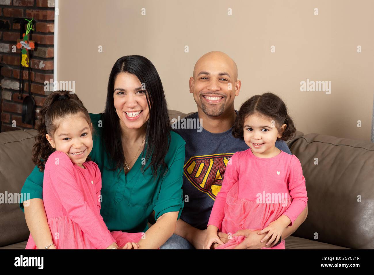 Ehepaar zu Hause mit Töchtern im Alter von 5 und 3 Jahren Stockfoto