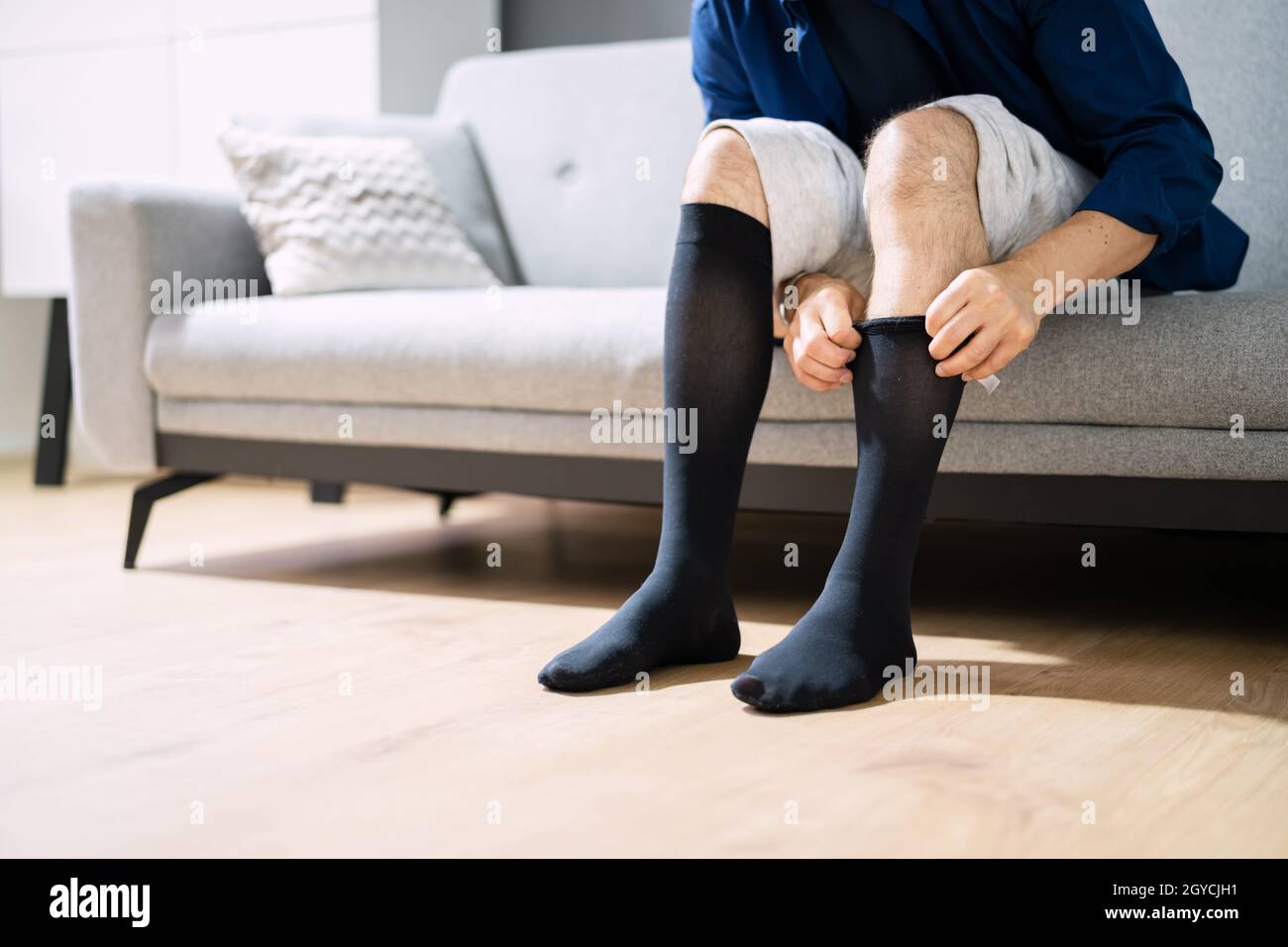 Mann, Der Medizinische Kompressionsstrümpfe Auf Die Beine Setzt  Stockfotografie - Alamy