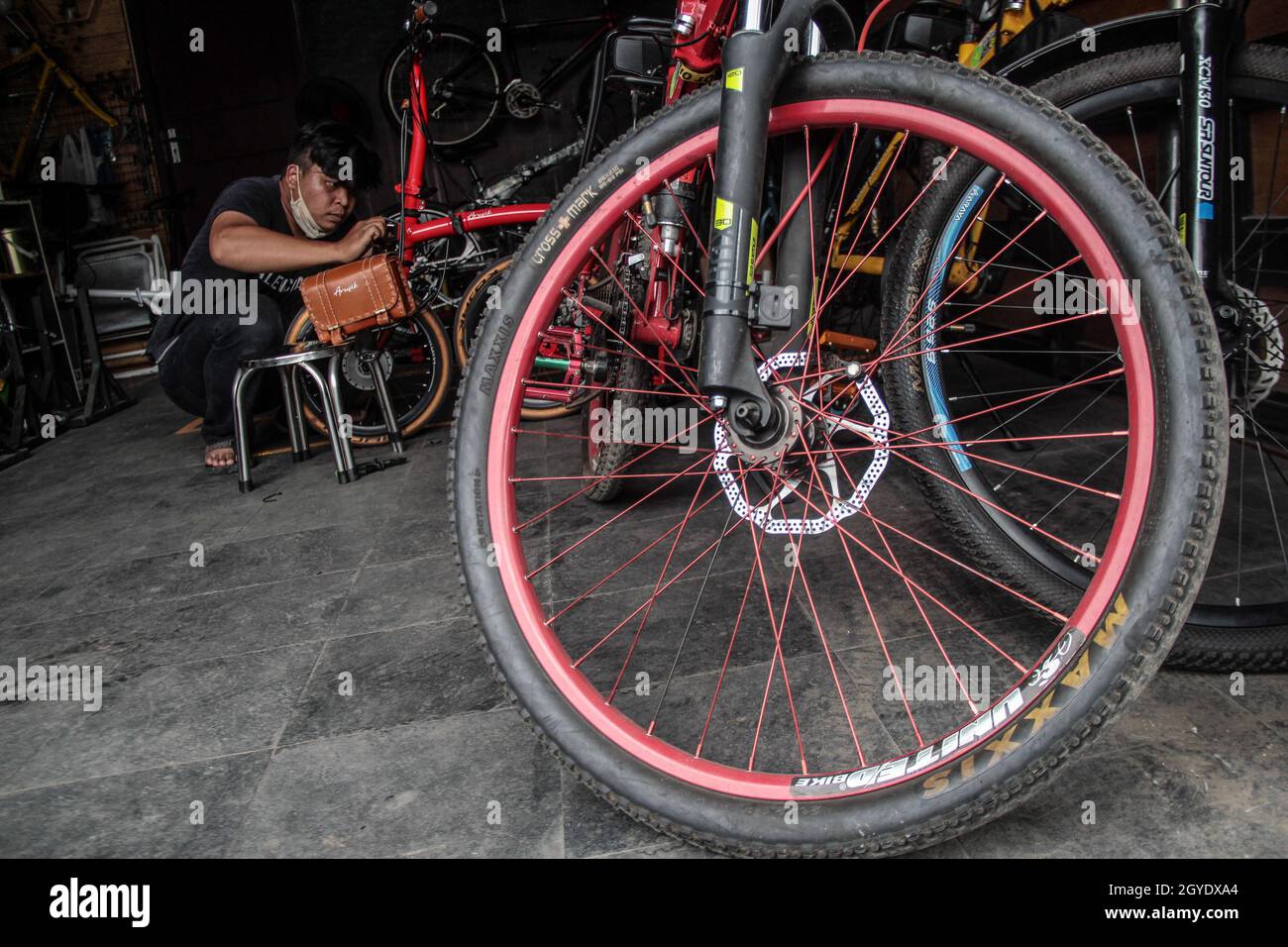 Ein Mechaniker installiert ein Batteriefach auf einem Faltfahrrad, das in der Werkstatt von Arusik Bikes in Bandung zu einem Elektrofahrrad umgebaut wird. Die Standard-Fahrrad-Innovation, die mit Strom modifiziert wird, basiert auf einem zusätzlichen Dynamo am Rad mit einem „Pedal Assist“- und „Gas-Gaspedal“-System, das bis zu 70 Kilometer hält. Die Custom-Akku-Power 'Arusik Bike' reicht von 250 bis 300 Watt bei einer Akkuladezeit von 4 Stunden von Null bis voll. (Foto von Algi Febri Sugita/SOPA Images/Sipa USA) Stockfoto