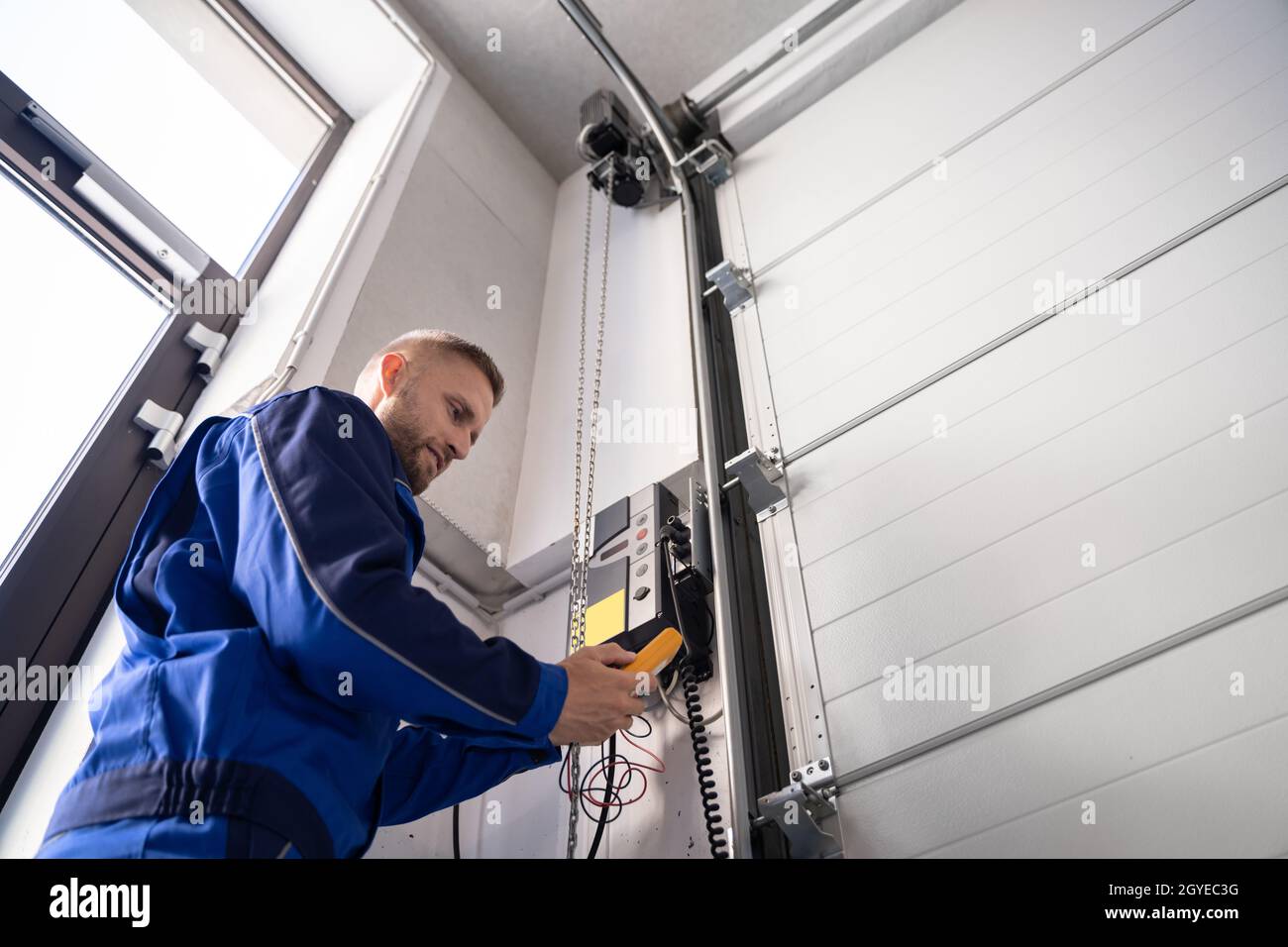 Garagentor Installation Und Reparatur Zu Hause. Auftragnehmer Mann Im Haus Stockfoto